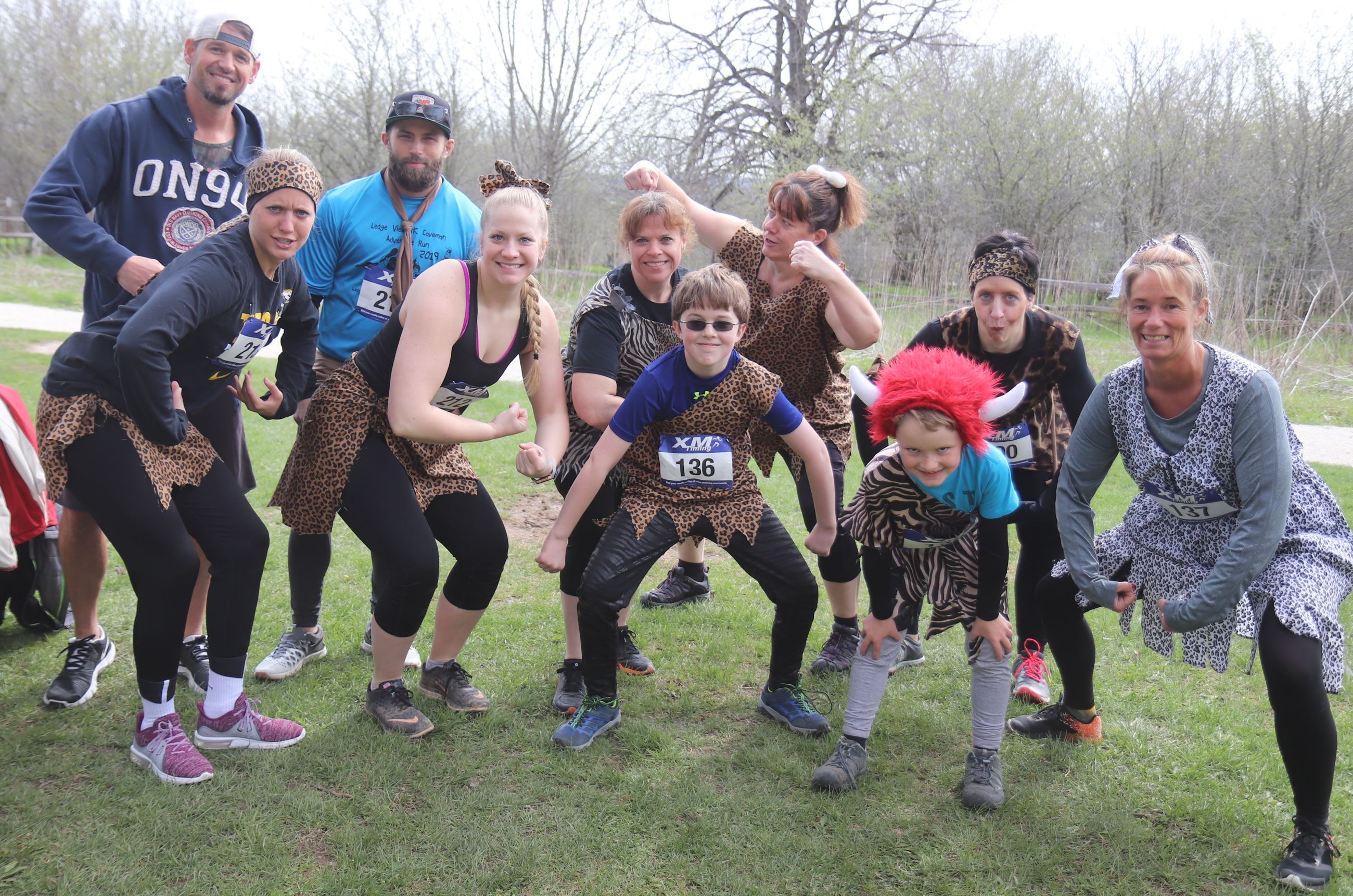 10 people posing in caveman costumes before a race