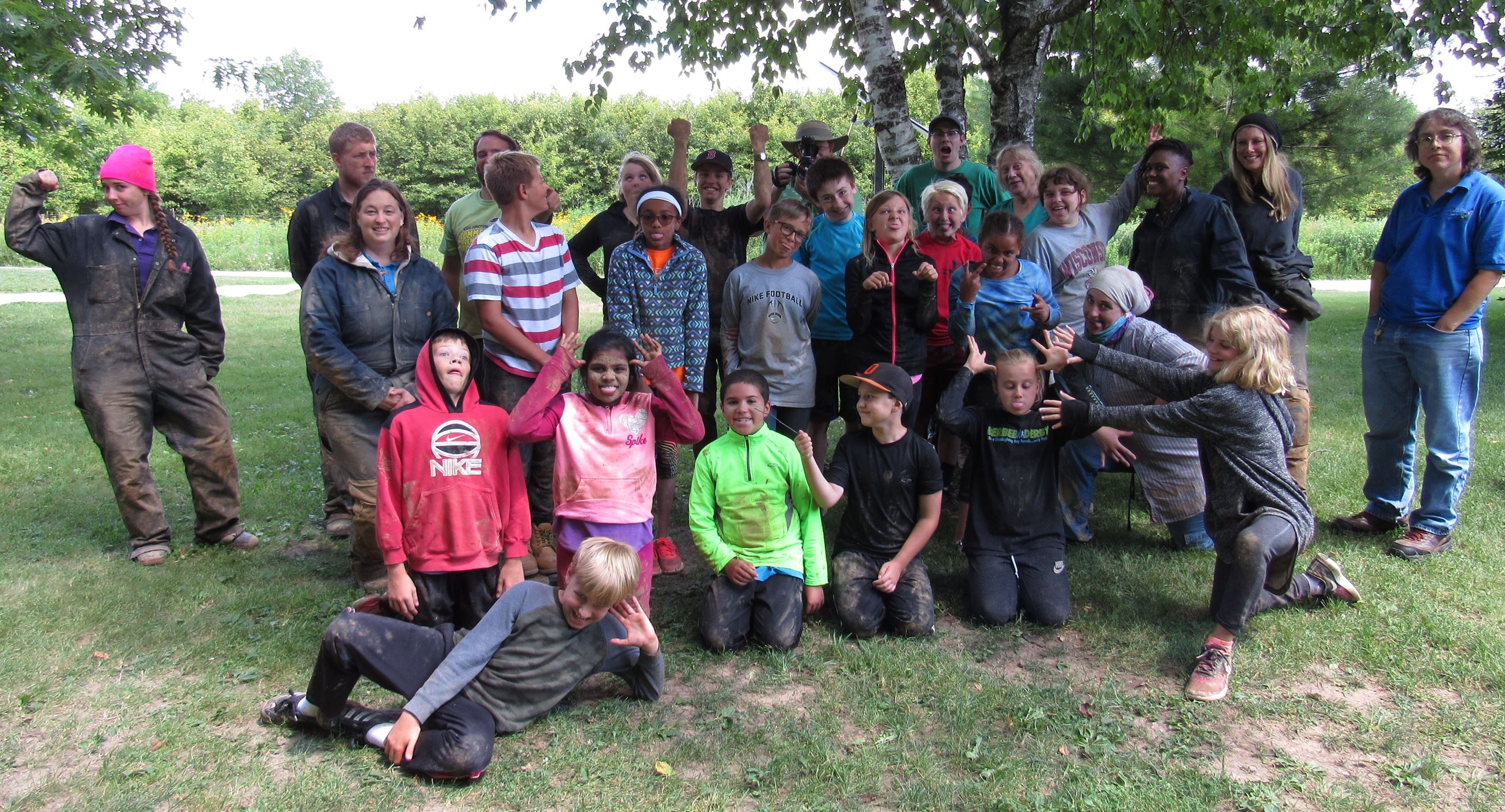 A group of muddy kids pulling funny faces. The kids just got back from caving.