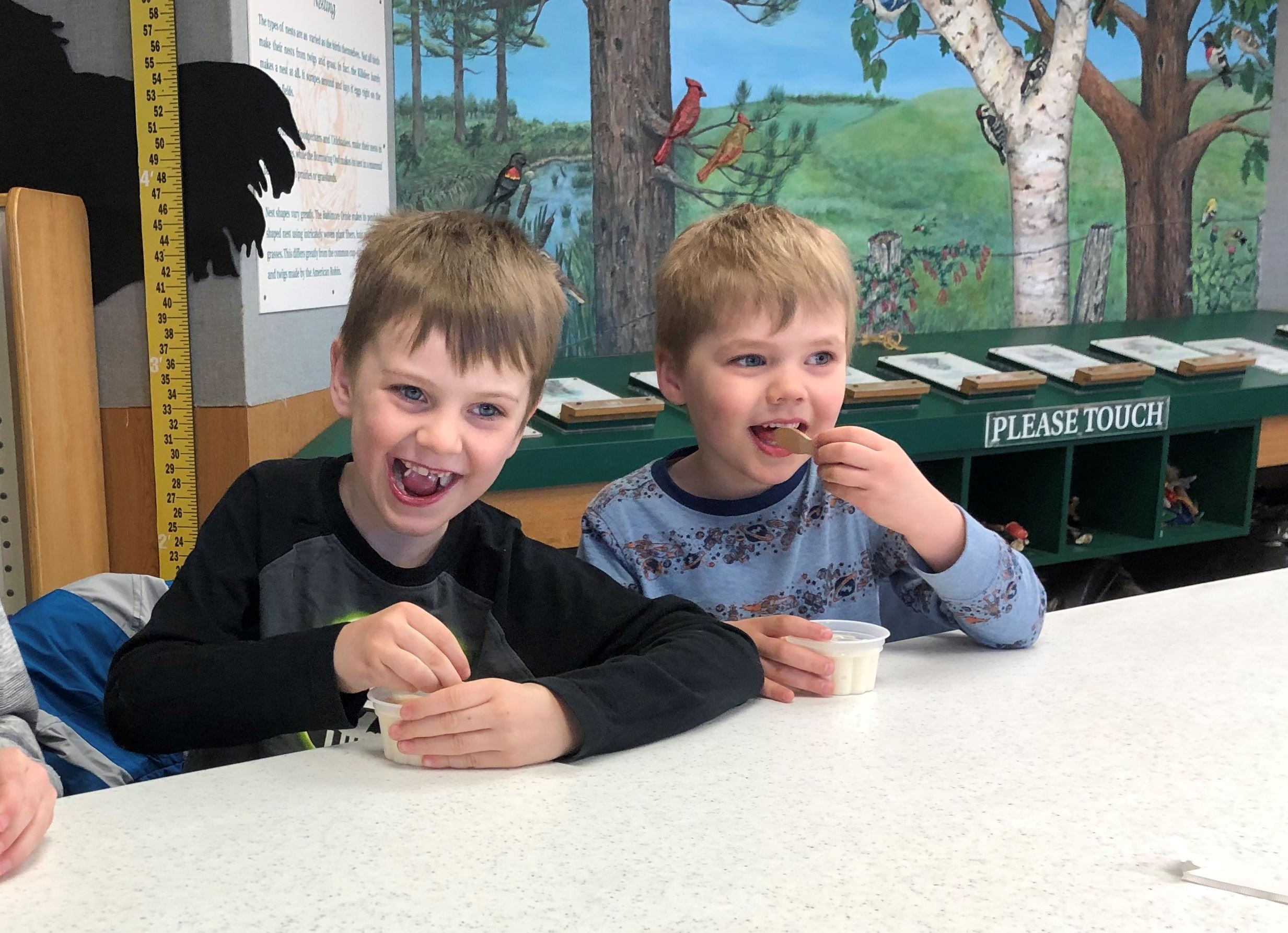 two boys eating ice cream with maple syrup on it