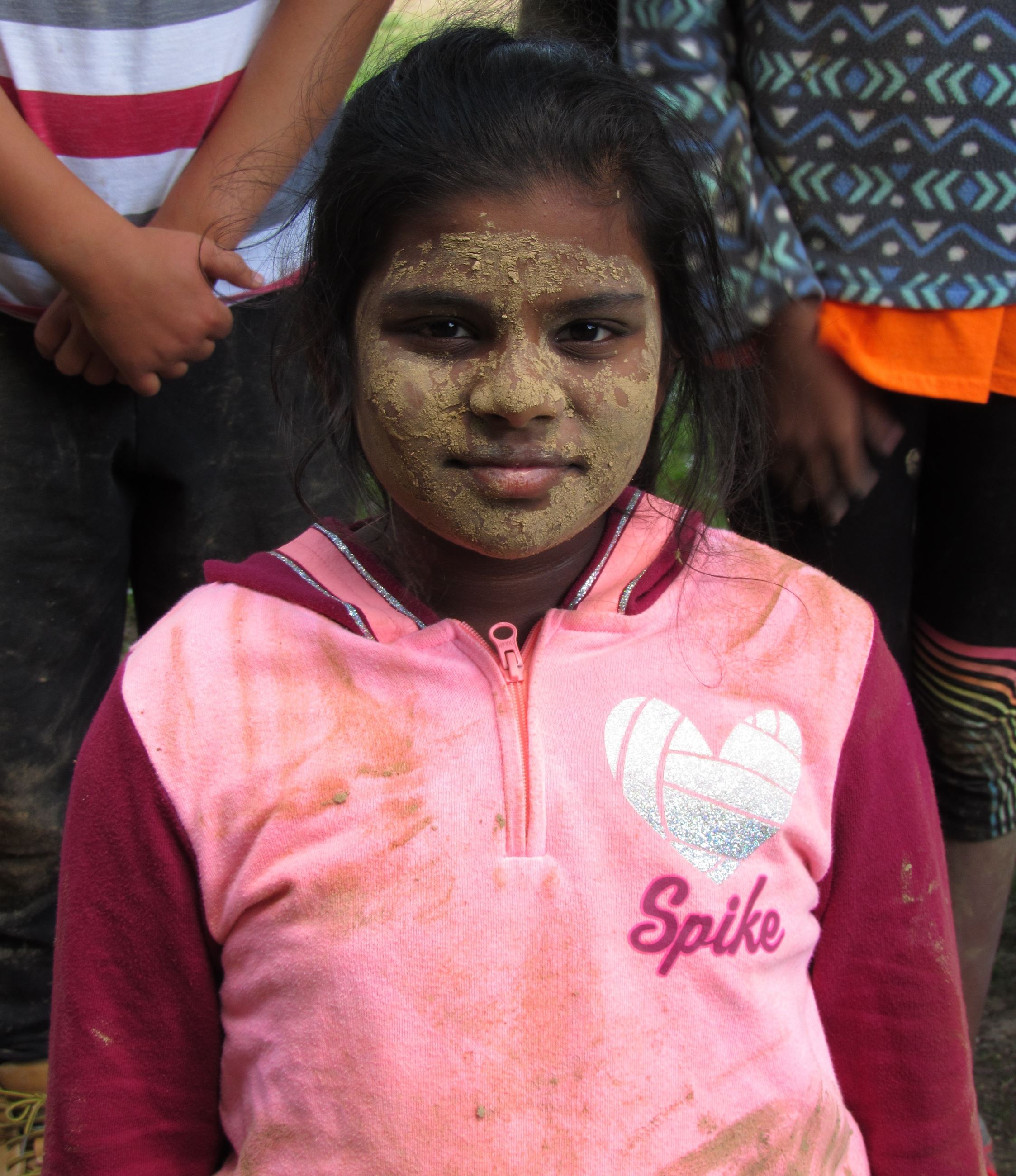 A girl with mud all over her face 
